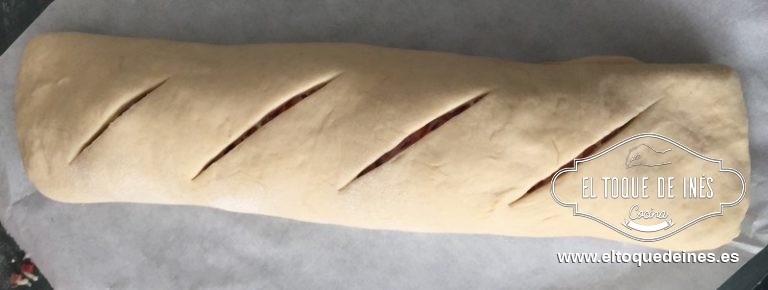 Ponemos el pan en la bandeja del horno cubierta con papel de hornear. Decoramos la superficie haciendo unas marcas profundas,yo uso un bisturí,pero sirve con un cuchillo bien afilado.