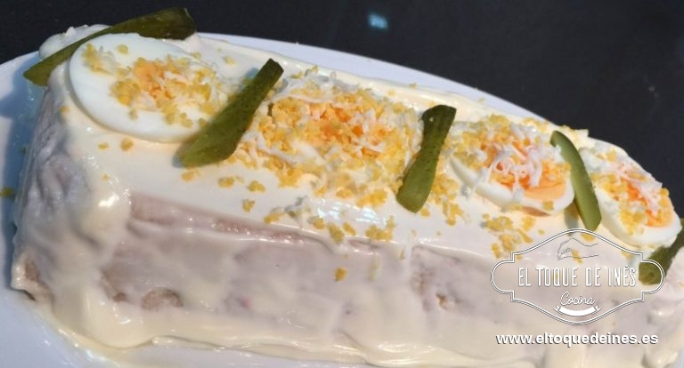 Desmoldamos pasado el tiempo, cubrimos con la mahonesa y decoramos con los pepinillos, las aceitunas (si queremos) y el huevo duro, un poco rallado y alguna lámina de huevo.