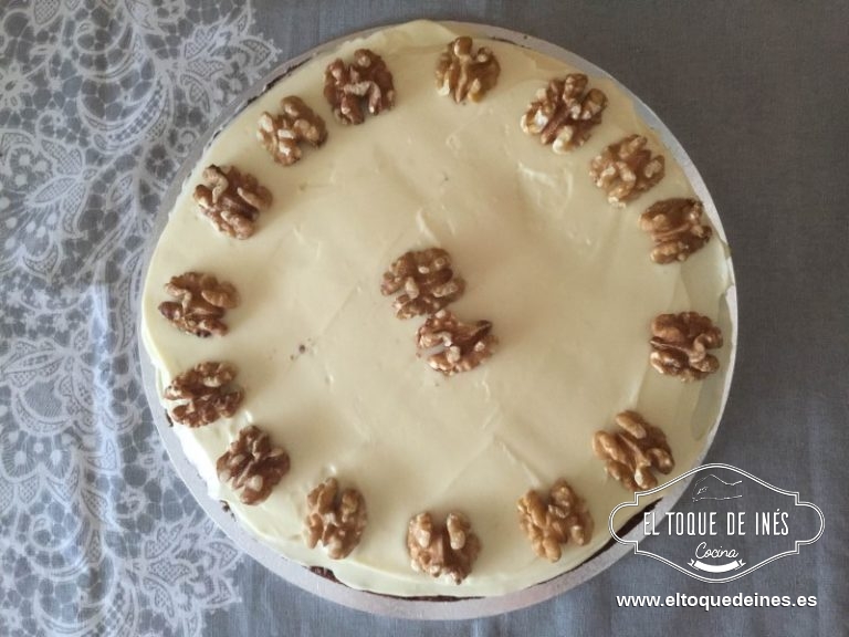 Dividir al medio el bizcocho y echar parte del relleno, tapar con la otra mitad y echar encima la cobertura.
Adornar con unas cuantas nueces.