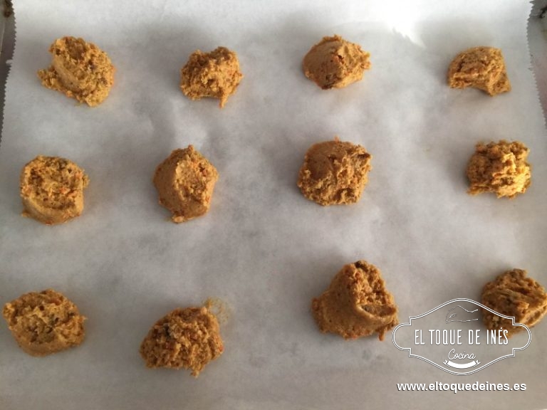 Precalentamos el horno a 180º, forramos una bandeja del horno con papel vegetal y con ayuda de dos cucharas vamos formando bolas, es muy pegajosa, yo intenté aplanarla un poco y se me quedaba pegada así que las dejé tal cual con ayuda de la cuchara.