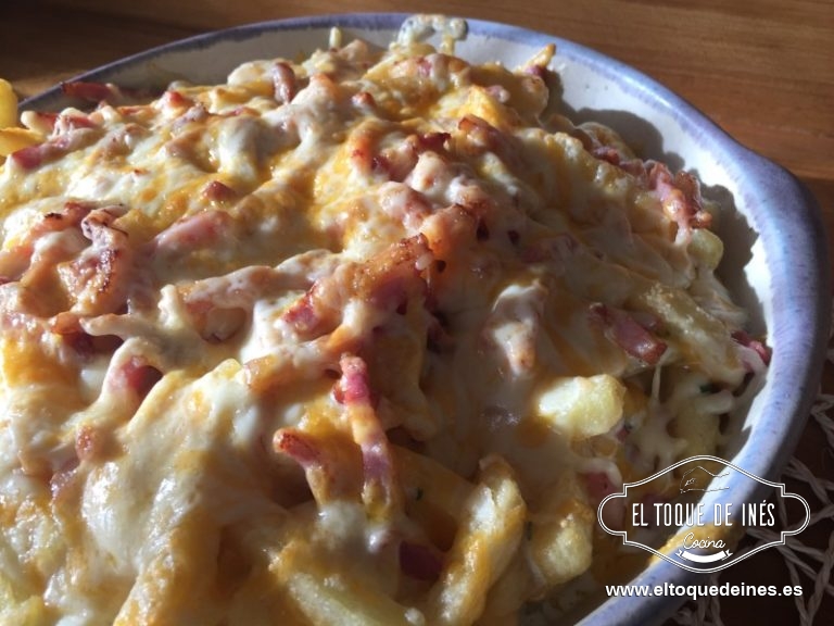 Vertemos sonre las patatas la salsa reservada, encima de la salsa repartimos el bacon bien y al final del todo esparcimos el queso rallado, que es una mezcla de 4 quesos (massdam, gouda, cheddar y curado) y metemos al horno a gratinar hasta que se fundan los quesos, dependerá del horno, el mío en 6 minutos estaba.