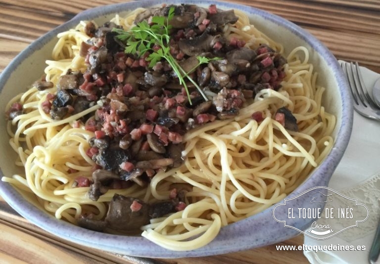 Echamos los espaguetis en una fuente o servimos individualmente , encima la salsa de queso y al final los champiñones con el jamón.