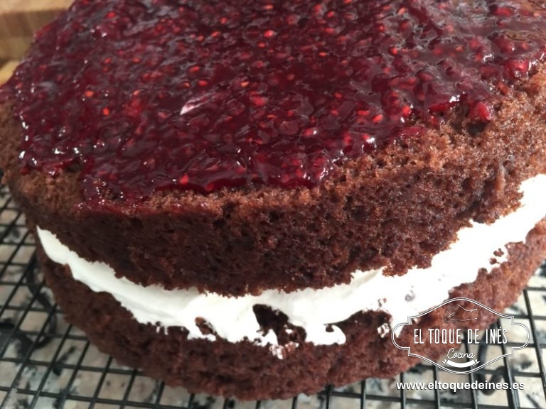 Partimos nuestro bizcocho en tres, sobre la primera capa extendemos la mermelada de frambuesas, tapamos con la segunda capa de bizcocho y echamos la nata montada y por último ponemos la tercera capa de bizcocho.