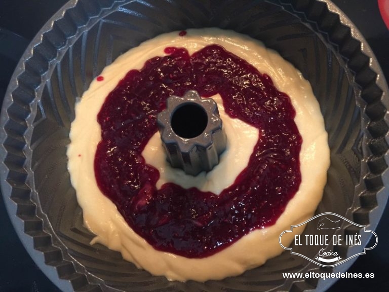 Vertemos en el molde la mitad de la masa o un poco más; repartimos la mermelada de frambuesas en el medio de la masa.