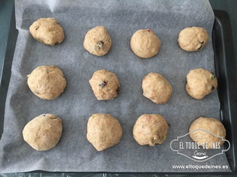 Una vez que está ya crecida la presionamos para desgasificar y la dividimos en 12 porciones más o menos iguales, les damos forma de bolita y las colocamos espaciados sobre la bandeja del horno cubierta de papel de hornear.