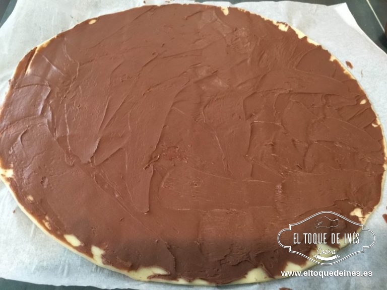 Extendemos una de las láminas  de hojaldre y untamos toda la superficie con la crema de cacao.