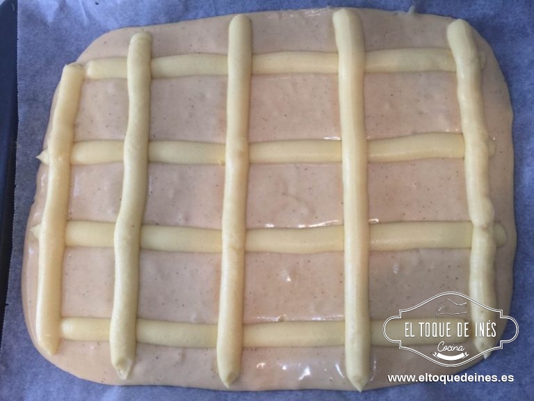 Sobre una bandeja de horno de 30x40 ponemos un papel de hornear y echamos nuestra mezcla, yo extendí un poco con la espátula para que quedase más igualada.