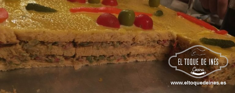 Lo cubrimos con mahonesa y decoramos con las aceitunas , pepinillos, cherrys y el pimiento que dejamos reservado .