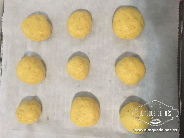 Cada porción la boleamos para que nos quede sin fisuras y vamos colocando encima de papel de hornear sobre la bandeja del horno que vayamos a usar.