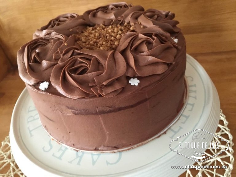 Finalizamos cubriendo toda la tarta y paredes con trufa e igualamos usando una espátula lisa u ondulada, eso va en el gusto de cada uno y adornáis con lo que queráis, o rosas de trufa o rosas de fondant, granillo de almendra (si no sois alérgicos a los frutos secos),etc eso es ya muy personal.