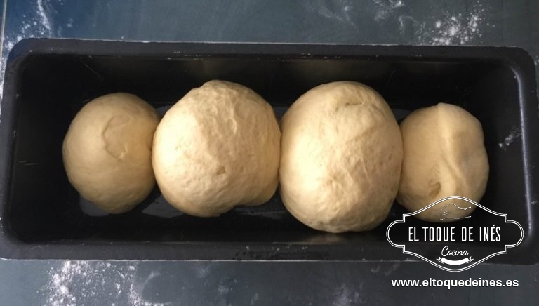 Sacamos la masa una vez haya aumentado y sobre una superficie algo enharinada la amasamos un poco, dividimos en 3-4 partes y boleamos; vamos colocando en el molde pegados unos a otros.