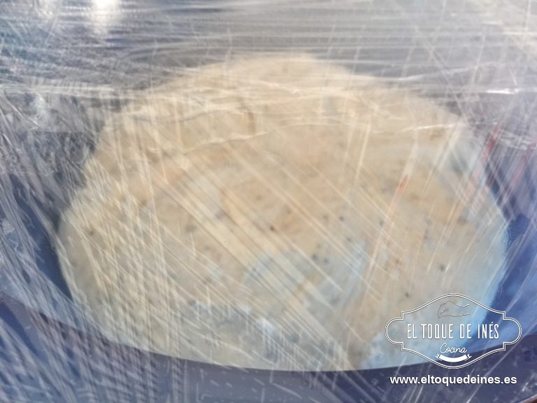 Echamos la masa sobre el mesado algo enharinado, cogemos pellizcos de las esquinas de la masa y lo traemos al centro de la masa, así con toda la masa; formamos una bola y echamos en un bol enharinado y tapamos con film transparente para que levede como unas 4 h a temperatura ambiente en una zona fuera de corrientes; yo metí el bol en el microondas.