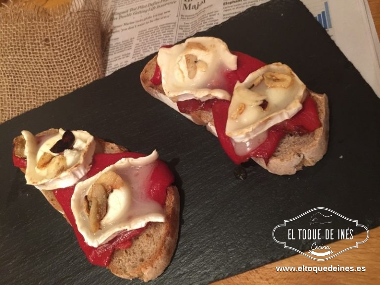 Mientras podemos ir tostando el pan en rebanadas, colocamos los pimientos con las láminas de ajo y mientras le damos un vuelta y vuelta en la sartén a los medallones de queso de cabra; colocamos en las tostas.