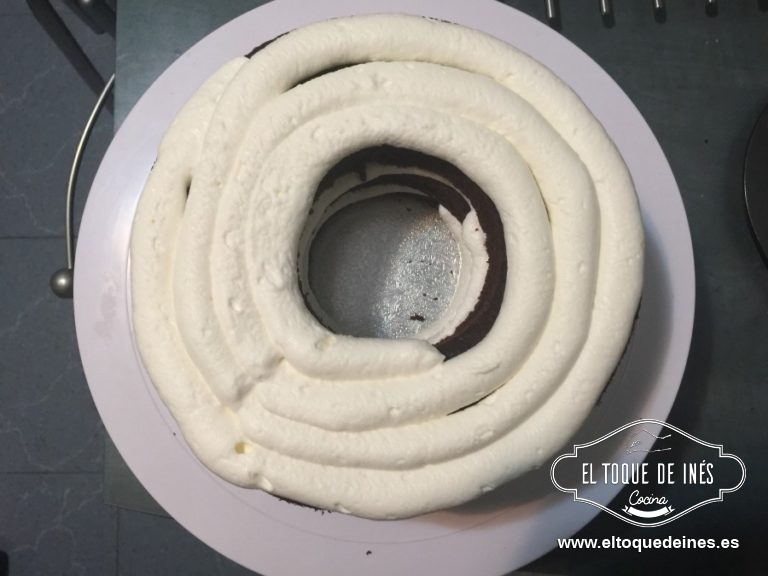 Colocamos sobre una base o plato, o bandeja la primera capa de bizcocho y repartimos nata por encima del bizcocho.