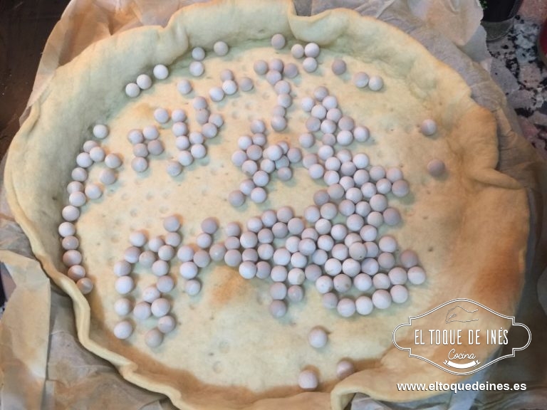 Colocamos la masa en el molde que vamos a usar , le colocamos peso sobre la base y horneamos unos 10 minutos a 150ºC.
