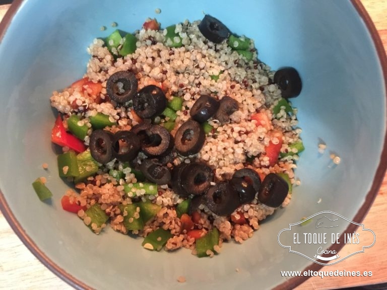 En un bol mezclamos la quinoa con los pimientos y los aros de aceitunas negras.