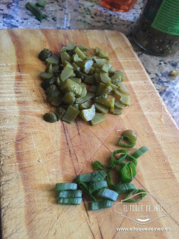 Mientras picamos los pepinillos  la cebolleta, bien picado todo.