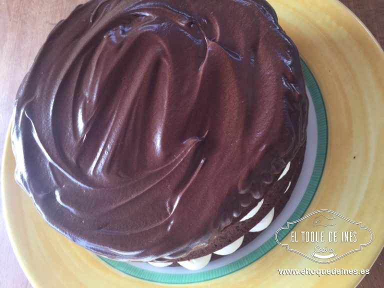 Por último el bizcocho nos queda, repartimos la cobertura de chocolate y decoramos con un poco de nata y los frutos del bosque.