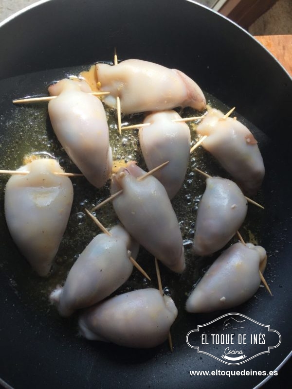 Salteamos los chipirones rellenos en una sartén con un poquitín de aceite, simplemente para que cojan color. Los dejamos en una olla amplia reservados.