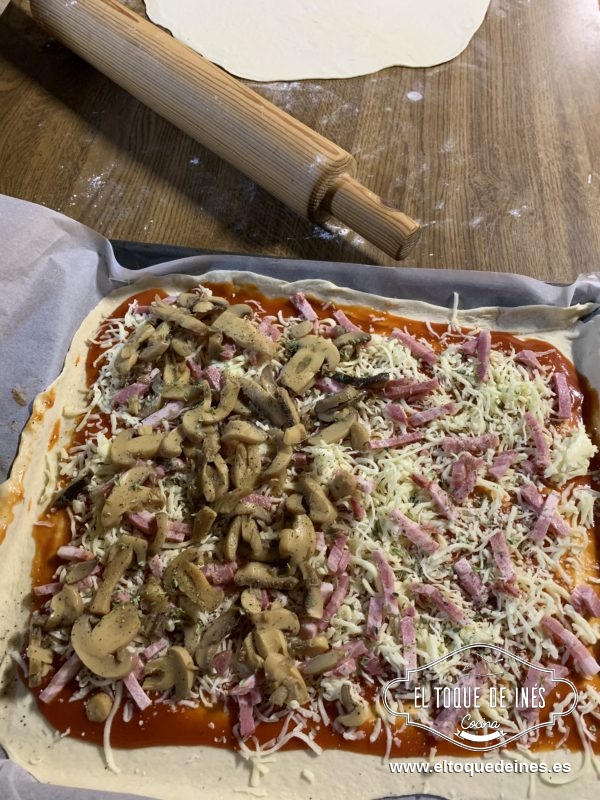 Repartís la mozzarella y el bacon por encima del tomate.