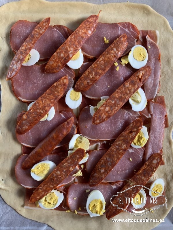 Colocamos encima El jamón serrano, encima el lomo por toda la superficie, los huevos cocidos en rodajas y por último el chorizo.