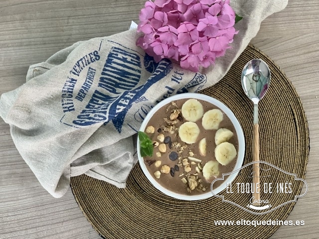 Vertemos en nuestro cuenco y decoramos con rodajas de plátano, las pepitas de chocolate, las avellanas y una poquita granola.