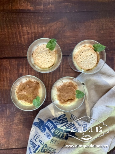 Vertemos las natillas en las copas o cuencos, espolvoreamos con canela  y colocamos la galleta. 