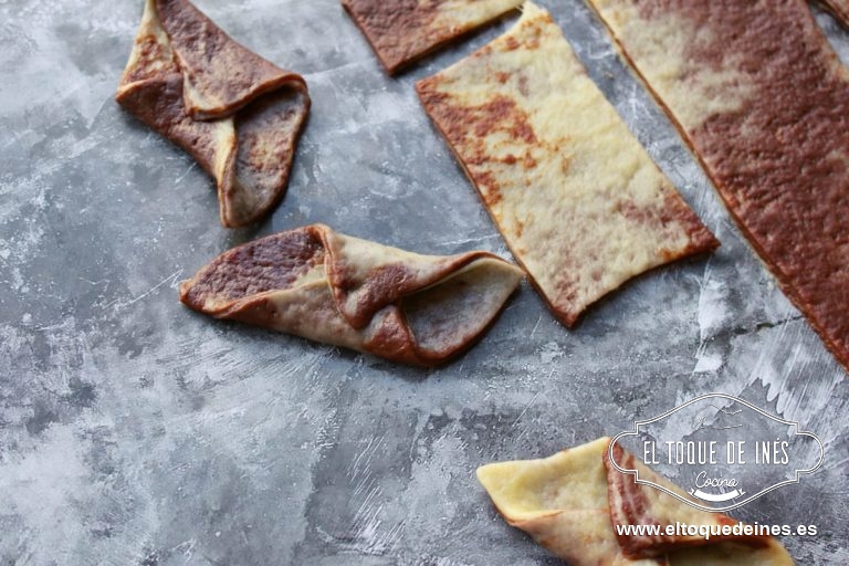 Cortamos la masa en cuadrados de unos 4 centímetros y formamos los pestiños uniendo dos de los vértices opuestos y los plegamos hacia el centro.