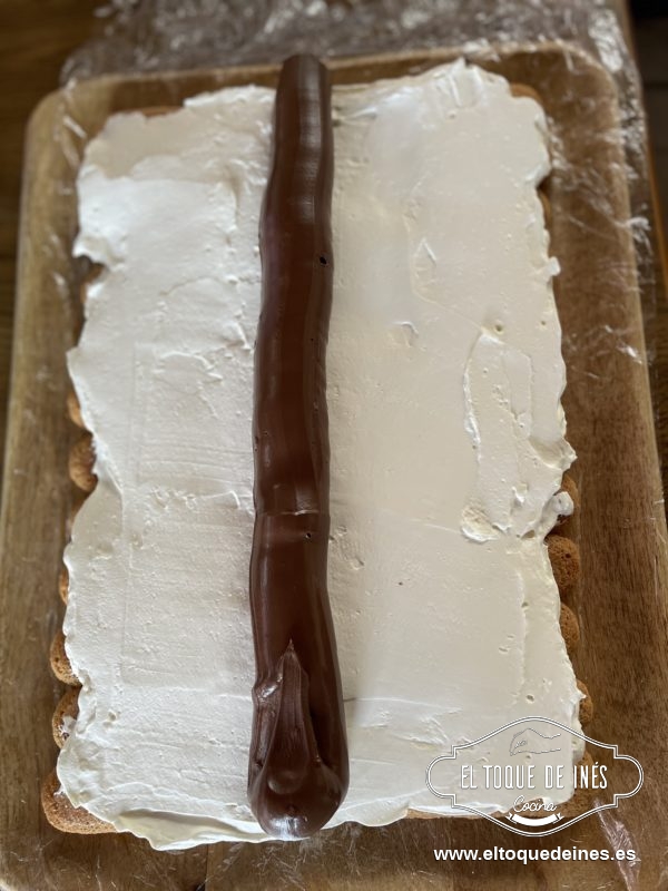 Metemos la crema de cacao en una manga pastelera y le cortamos la punta bastante para echar un churro de crema de cacao en el centro de la mezcla.