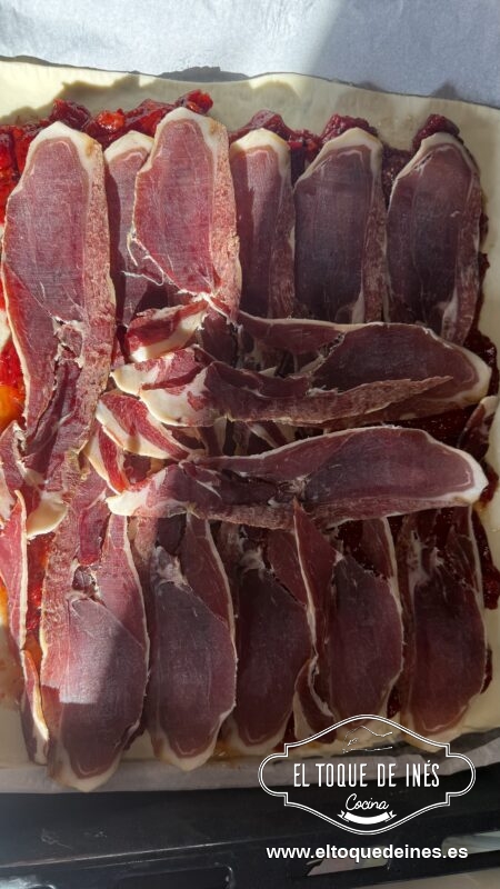 Añade las lonchas de jamón serrano por encima del pimiento caramelizado.